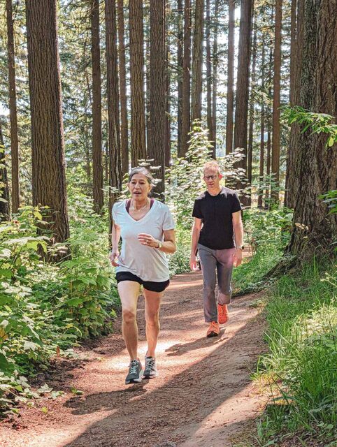 A member and Brian moving down a forest trail on Mt. Tabor